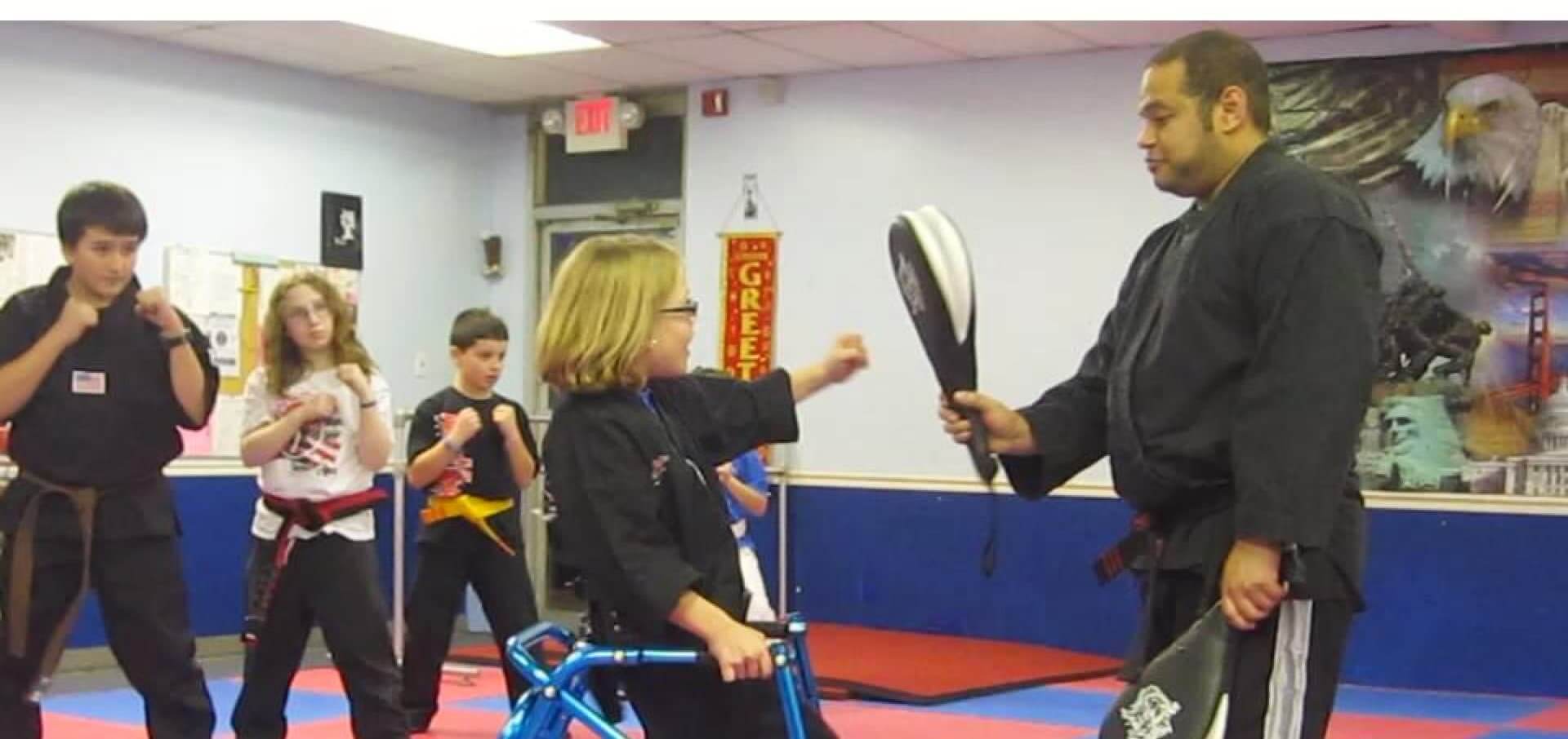 karate instructor assisting little girl