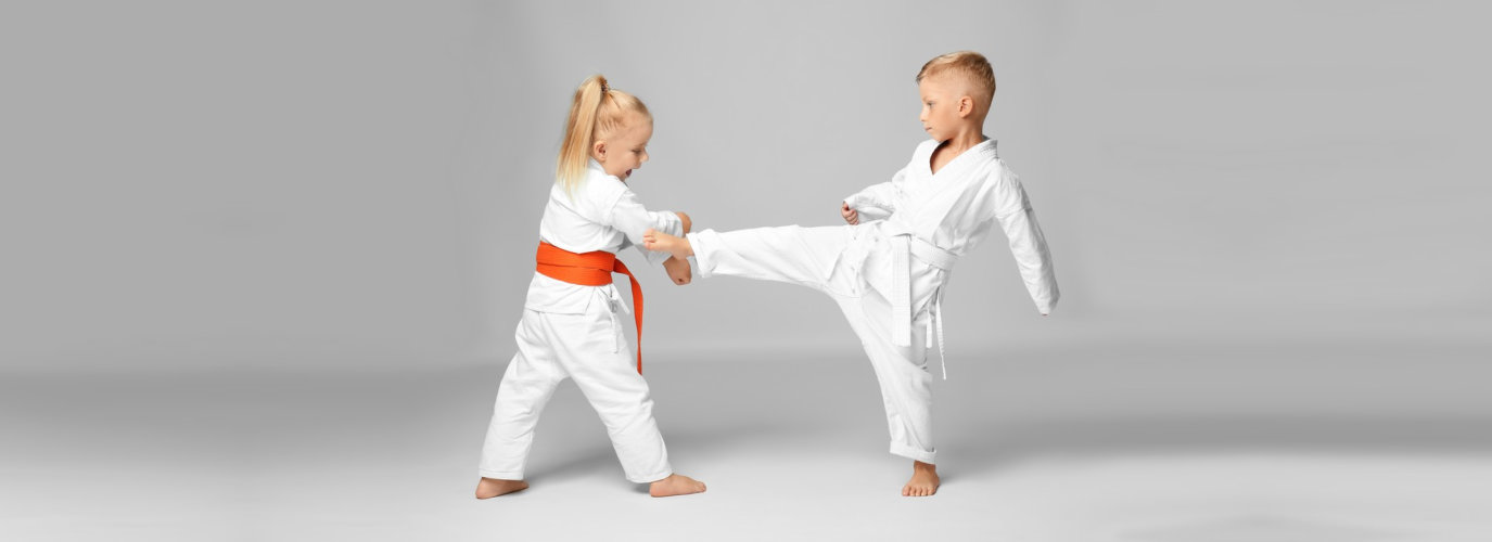 little children practicing karate on light background